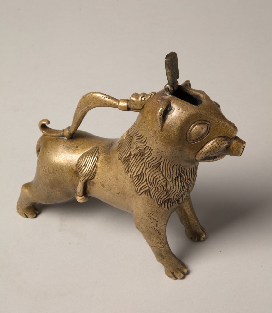 An aquamanile in the form of a lion, Early 13th century
Germany, probably Lower Saxony
cast copper alloy with fine soldered repairs to the handle at its upper and lower connecting points. Hairline fractures to the legs in two places. The hinged lid a modern replacement.
6 3/4 x 9 1/8 x 2 1/8 inches
(17.1 x 22.9 x 5.5 cm)